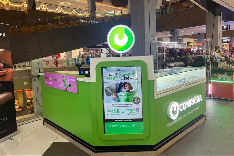 Green Compasia kiosk with digital display in a mall setting